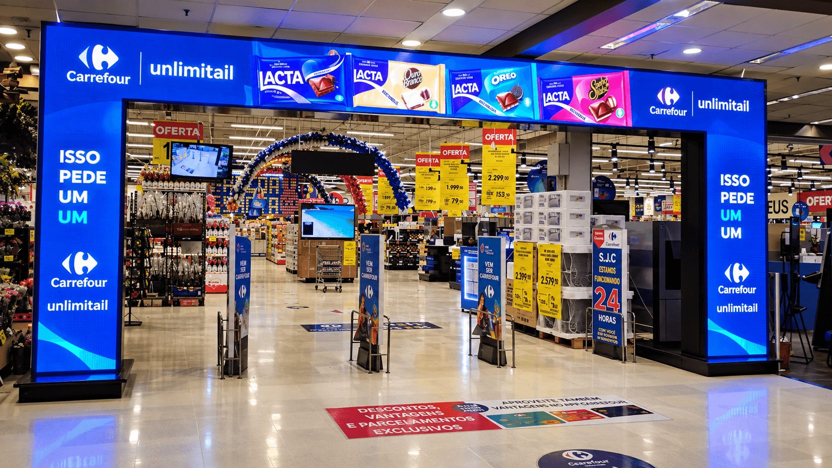 Pórtico digital de LED na entrada de uma loja Carrefour, com identificação Unlimitail, instalado pela Tiagora